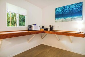Eine Küche mit Holzarbeitsplatte, einer Mikrowelle, einer Kaffeemaschine und einem Bild einer Unterwasserwelt.