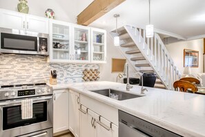 A modern kitchen with a built-in oven, microwave, and dishwasher.