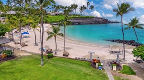 A beach resort with a clear view of the ocean, palm trees, and a well-maintained lawn area. - Ground-Floor Mauna Lani Golf Villa- Fairway Views, Beach Access, Hot Tub, Pool (Kamuela)