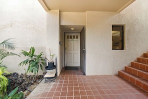 A building entrance with a tiled floor, a door, and a small window. - New Ground-Floor Fairway Stay Near A-Bay Beach (Waikoloa)