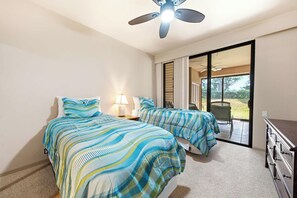 A hotel room with two beds, a ceiling fan, a desk, and a view of the outdoors. - New Ground-Floor Fairway Stay Near A-Bay Beach (Waikoloa)