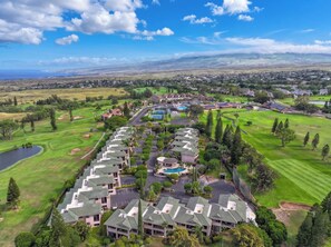Um campo de golfe com área residencial, incluindo casas e piscina.