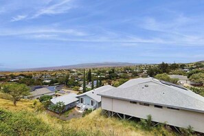 A residential area with houses, some with solar panels, and a clear view of distant hills. - NEW Fall Sale Private Waikoloa Home with Coastal Views and Hot Tub (Waikoloa Village)