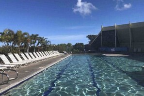A swimming pool with clear water, sun loungers, and palm trees. - NEW Fall Sale Private Waikoloa Home with Coastal Views and Hot Tub (Waikoloa Village)
