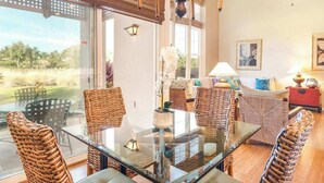 A dining area with wicker chairs, a glass table, and a view of the outdoors. - *New* Fall Sale Walk to A-Bay from a Quiet Waikoloa Cul-de-Sac (Waikoloa)