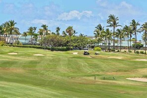 A golf course with sand bunkers, palm trees, and a clear sky. - Waikoloa Beach Resort Villa-Golf, Pools, Hot Tub, Local Shops, Dining, Beach Fun (Waikoloa)