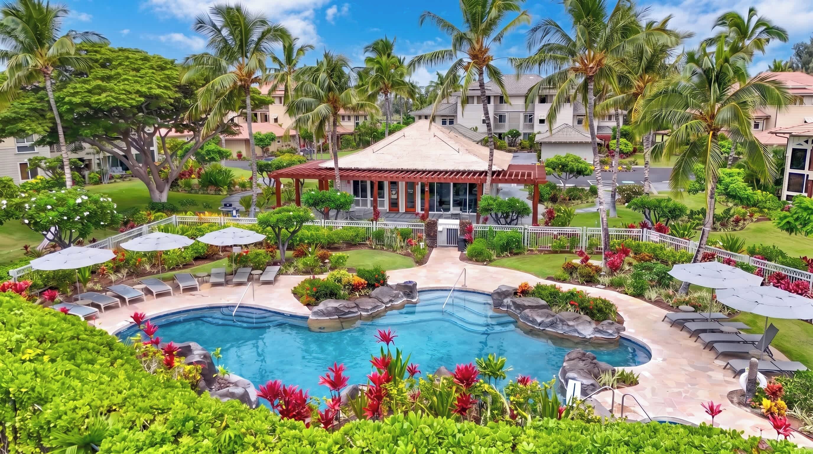 A resort with a swimming pool, lounge chairs, and palm trees.