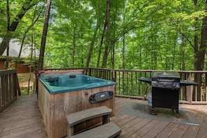 A wooden deck with a hot tub and a grill. - Bears in the Mist (Sevierville)