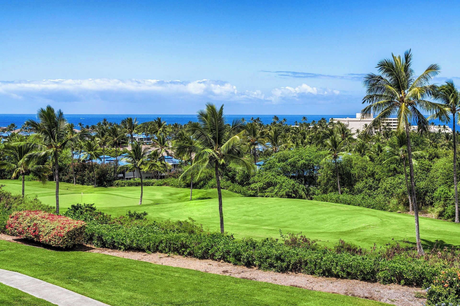 A golf course with a view of the ocean and palm trees.