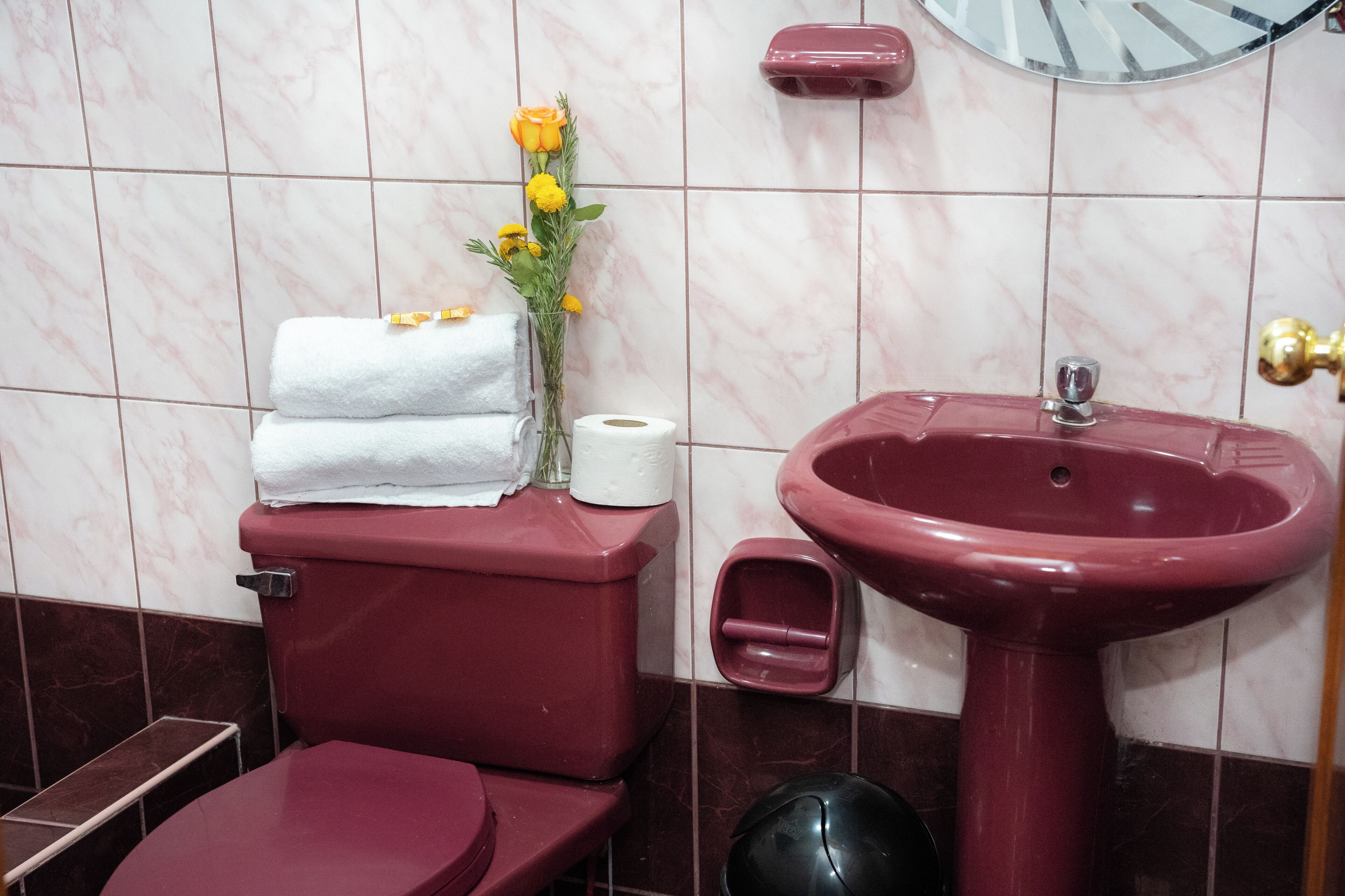 A bathroom with a toilet, sink, and marble tiles.