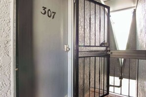 A door with the number 307, a metal gate, and a textured wall. - NEW Downtown Hilo Bay Base for 31+ Night Stays (Hilo)