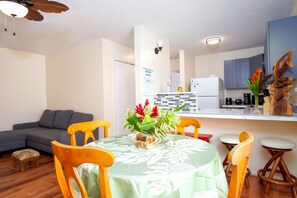 A compact living space with a dining area, kitchenette, and a gray sofa. - NEW Downtown Hilo Bay Base for 31+ Night Stays (Hilo)