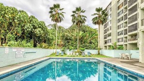 A swimming pool with palm trees and a building in the background. - New Fall Deal Hilo 2BR Waterfront Condo by Carlsmith Lagoons (Hilo)