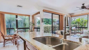 Una cucina moderna con una grande isola, lavello in acciaio inossidabile e mobili in legno.