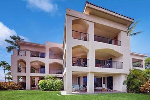 A multi-story hotel with balconies, a covered patio, and a well-maintained lawn. - *New* Fall Sale Freshly Updated Ground-Floor Waikoloa Getaway (Waikoloa Village)