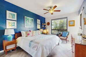 A bedroom with a bed, a ceiling fan, a window with a view, and artwork on the walls. - *New* Fall Sale Freshly Updated Ground-Floor Waikoloa Getaway (Waikoloa Village)