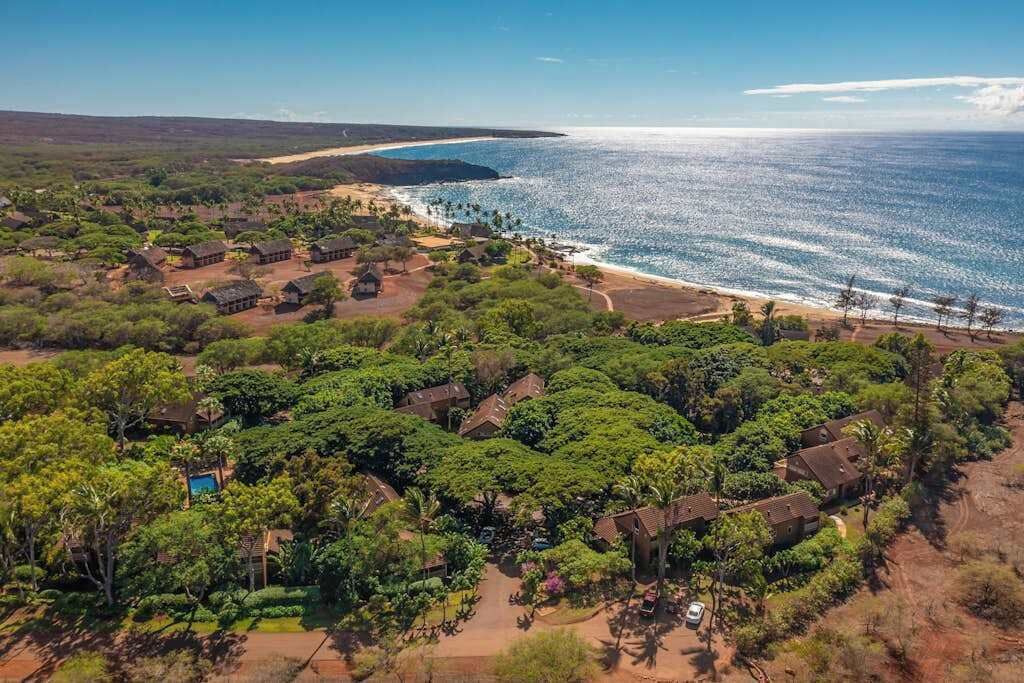 A coastal property with multiple houses, a swimming pool, and a beach view.