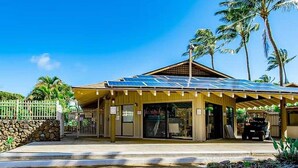 Um edifício com telhado solar, entrada coberta e parede de pedra.