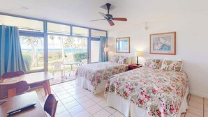 A room with two beds, a ceiling fan, a table with chairs, and a view of the outdoors. - New Fall Sale Ocean View Studio Near Kepuhi Beach and Sunset Pool (Maunaloa)