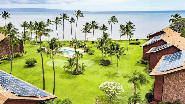 Ein Resort mit Pool, Palmen und Blick auf den Ozean.