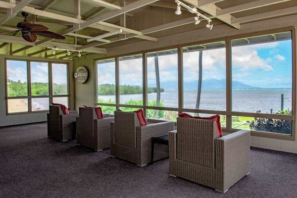 Covered lanai offers chairs, tables, ceiling fans, and ocean views