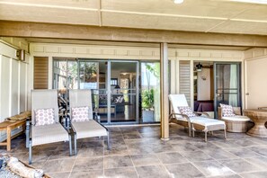 Un patio techado con asientos y vistas al interior.