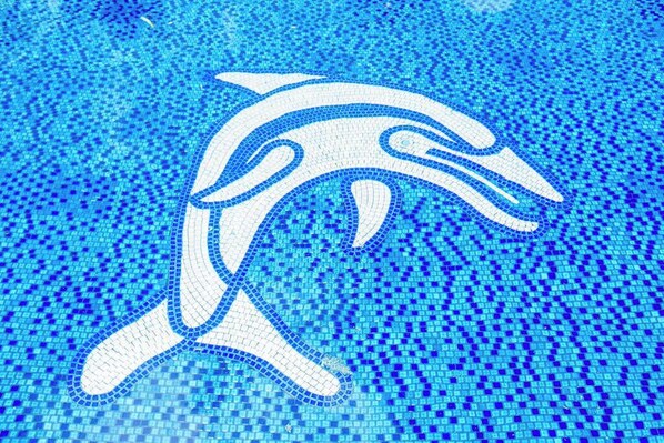 A mosaic of a dolphin swimming in a pool. - *NEW* Third-Floor Molokai Oceanfront Views with Pool (Kaunakakai)