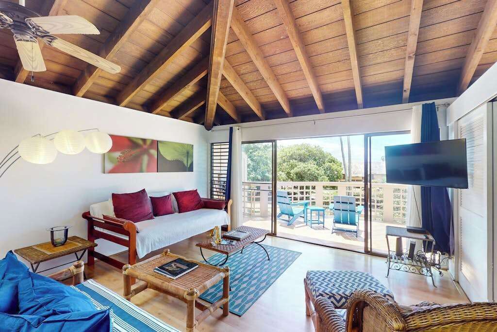 Open living room features comfortable seating and bright island views