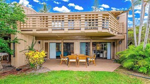 A modern house with a covered patio, a dining area, and a large window. - *New* Fall Sale Molokai Two-Bedroom Retreat by Kepuhi Beach (Maunaloa)