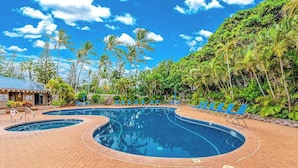 A swimming pool with blue water, surrounded by palm trees and a brick walkway. - *New* Fall Sale Molokai Two-Bedroom Retreat by Kepuhi Beach (Maunaloa)