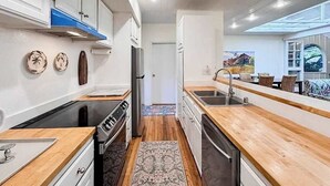 Uma cozinha moderna com bancadas de madeira, fogão e lava-louças.