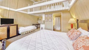 A hotel room with a large bed, a television, a desk, and a balcony. - *New* Fall Sale Molokai Studio for Poolside Sunsets Near Kaunakakai (Kaunakakai)