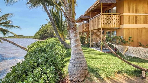 A wooden building with balconies, a hammock, and a palm tree. - *New* Fall Sale Molokai Studio for Poolside Sunsets Near Kaunakakai (Kaunakakai)