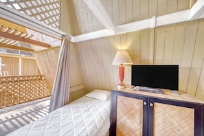 A hotel room with a bed, a TV on a wooden cabinet, and a window with a view of the outside. - Oceanfront Hotel Molokai 201 Studio Near Kaunakakai | Pool/Beach Access, Hammock (Kaunakakai)
