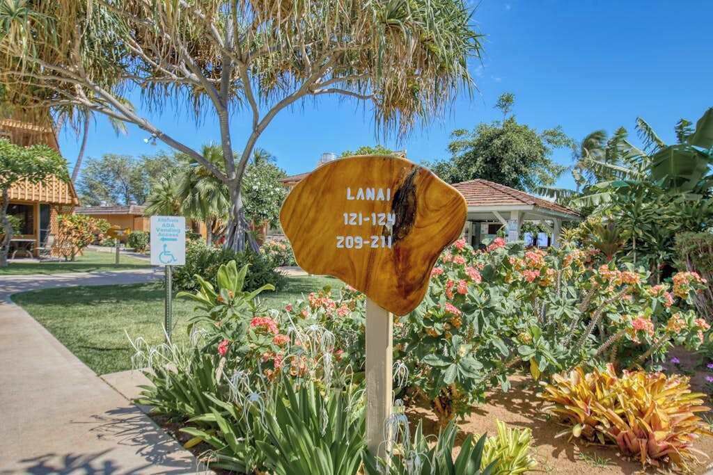 Señal con la inscripción 'LANAI 121-124 209-211' que indica los números de habitación.