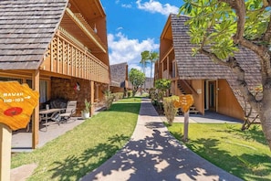 A resort with wooden buildings, a paved walkway, and a clear sky.