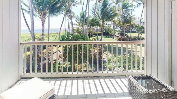 A balcony with a view of palm trees and a beach. - NEW Fall Sale Second-Floor Molokai Condo with Pool, Tennis and Views (Kaunakakai)