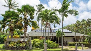 A hotel with a signboard, surrounded by palm trees and greenery. - NEW Fall Sale Second-Floor Molokai Condo with Pool, Tennis and Views (Kaunakakai)
