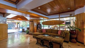 A spacious living area with a large sectional sofa, a coffee table, and a wooden ceiling. - NEW Fall $pecial Central Waikiki Condo Near Beach and Zoo (Honolulu)