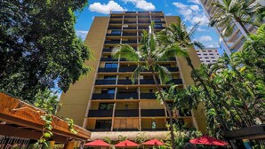 A multi-story hotel with balconies, surrounded by palm trees and a clear sky. - NEW Fall $pecial Central Waikiki Condo Near Beach and Zoo (Honolulu)