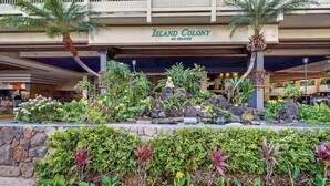 A hotel named 'Island Colony' with a landscaped entrance featuring tropical plants and a statue. - *New* 30-Night Waikiki Studio with Lanai and Pool (Honolulu)