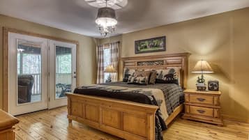 A bedroom with a wooden bed, a ceiling fan, a nightstand with a lamp, and a window with curtains.