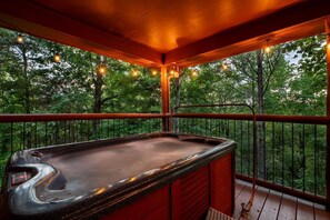 A hot tub on a wooden deck with a railing, surrounded by trees. - Can't Bear to Leave (Sevierville)