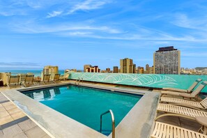 A rooftop pool with lounge chairs and a city skyline view. - *New* Waikiki Rooftop Retreat for 30-Night Stays (Honolulu)