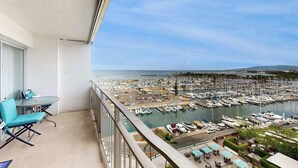 Een balkon met uitzicht op een jachthaven en boten.
