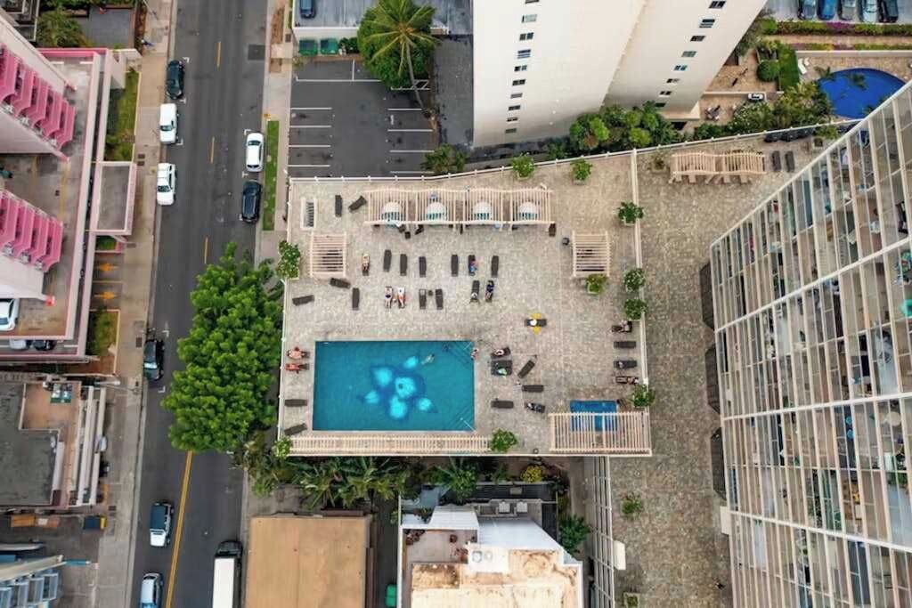 Un espace piscine aménagé sur le toit, avec des chaises longues et une piscine.