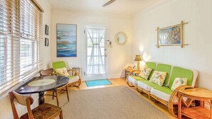 A room with a dining table, chairs, a sofa, a ceiling fan, and artwork on the walls. - *NEW* Diamond Head Cottage Near Waikiki, 30-Night Minimum (Honolulu)