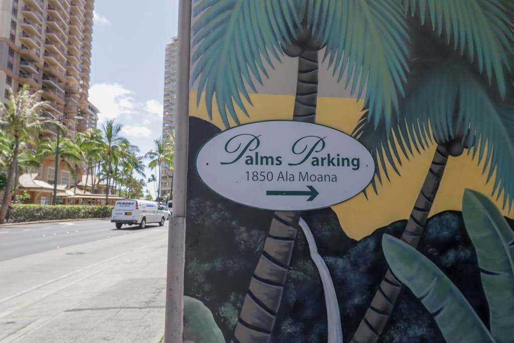 A sign for 'Palms Parking' with an arrow pointing right, located at 1850 Ala Moana.