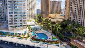 Um hotel moderno com várias varandas, piscina e paisagismo exuberante.