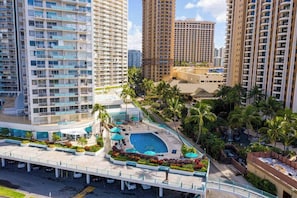 A high-rise hotel with multiple balconies, a swimming pool, and lush landscaping. - *NEW* Waikiki Marina-View Studio Near Ala Moana Beach (Honolulu)